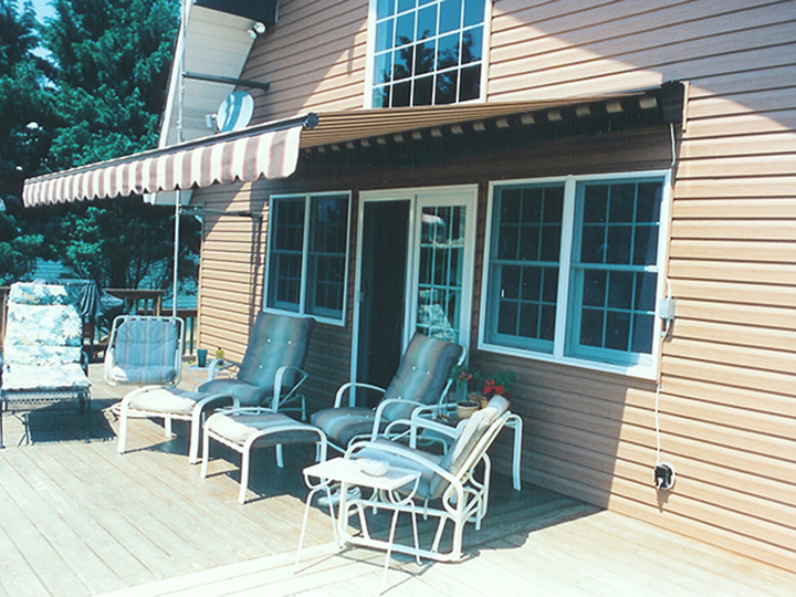 Striped awning extended over deck furniture